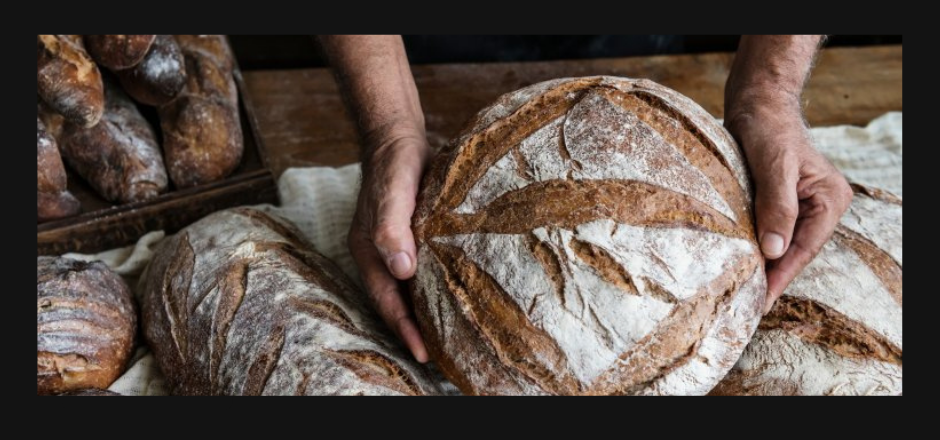 manos sosteniendo una hogaza de pan