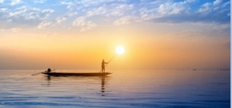 pescador en barca pescando al amanecer